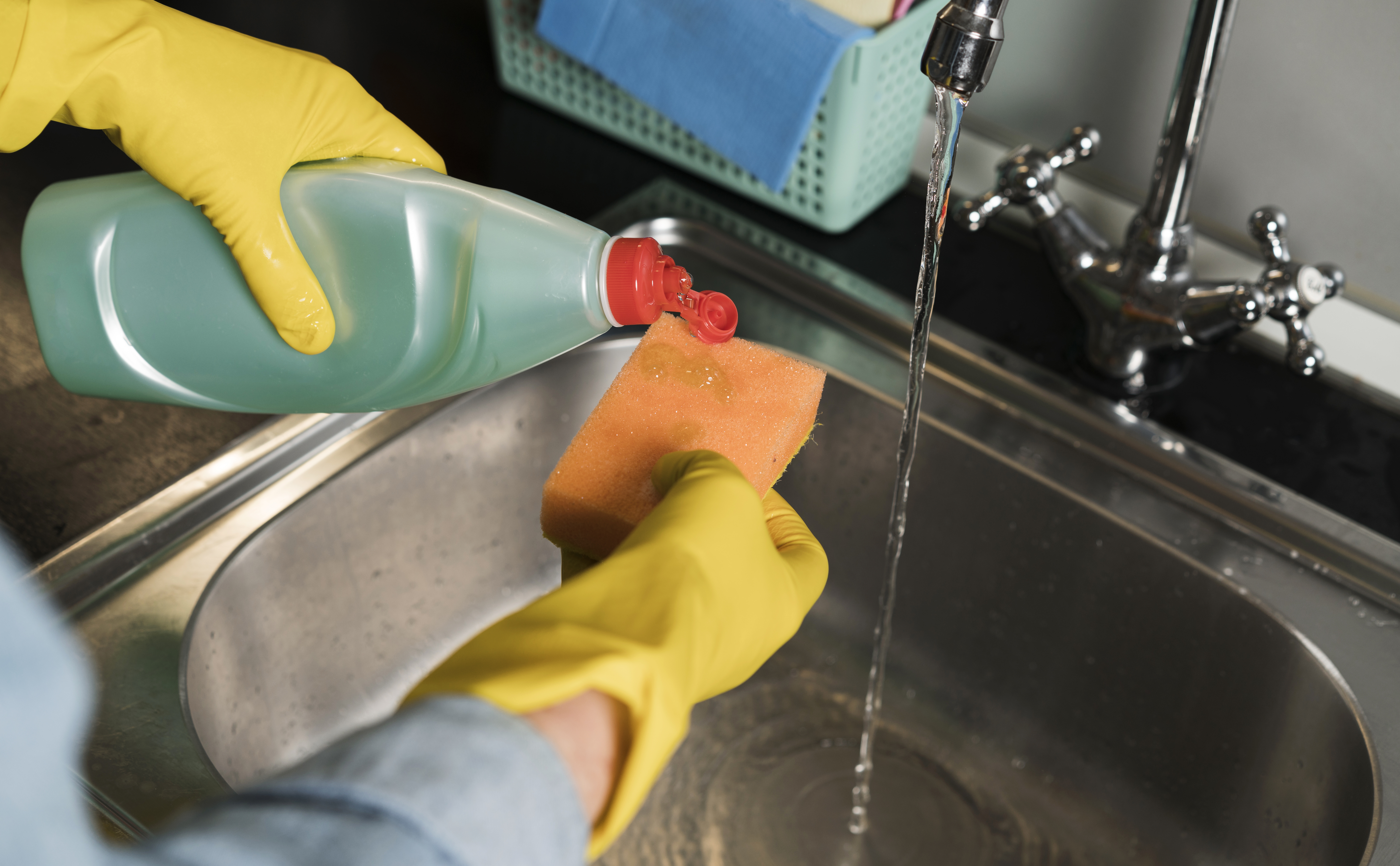 woman-with-rubber-gloves-cleaning-sink